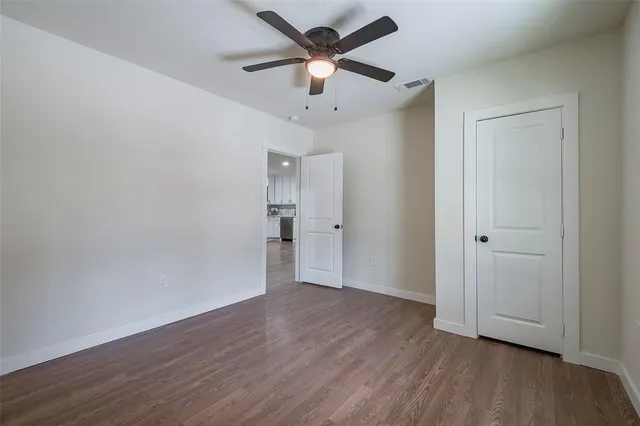an empty room with wooden floor a ceiling fan and closet