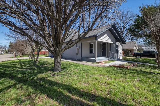 a view of a house with backyard and trees