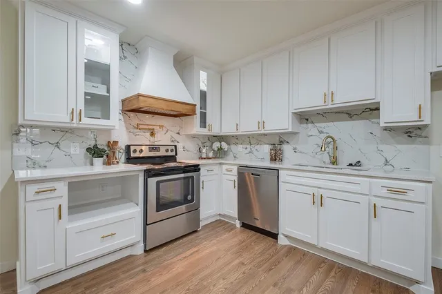 a kitchen with granite countertop white cabinets and white stainless steel appliances