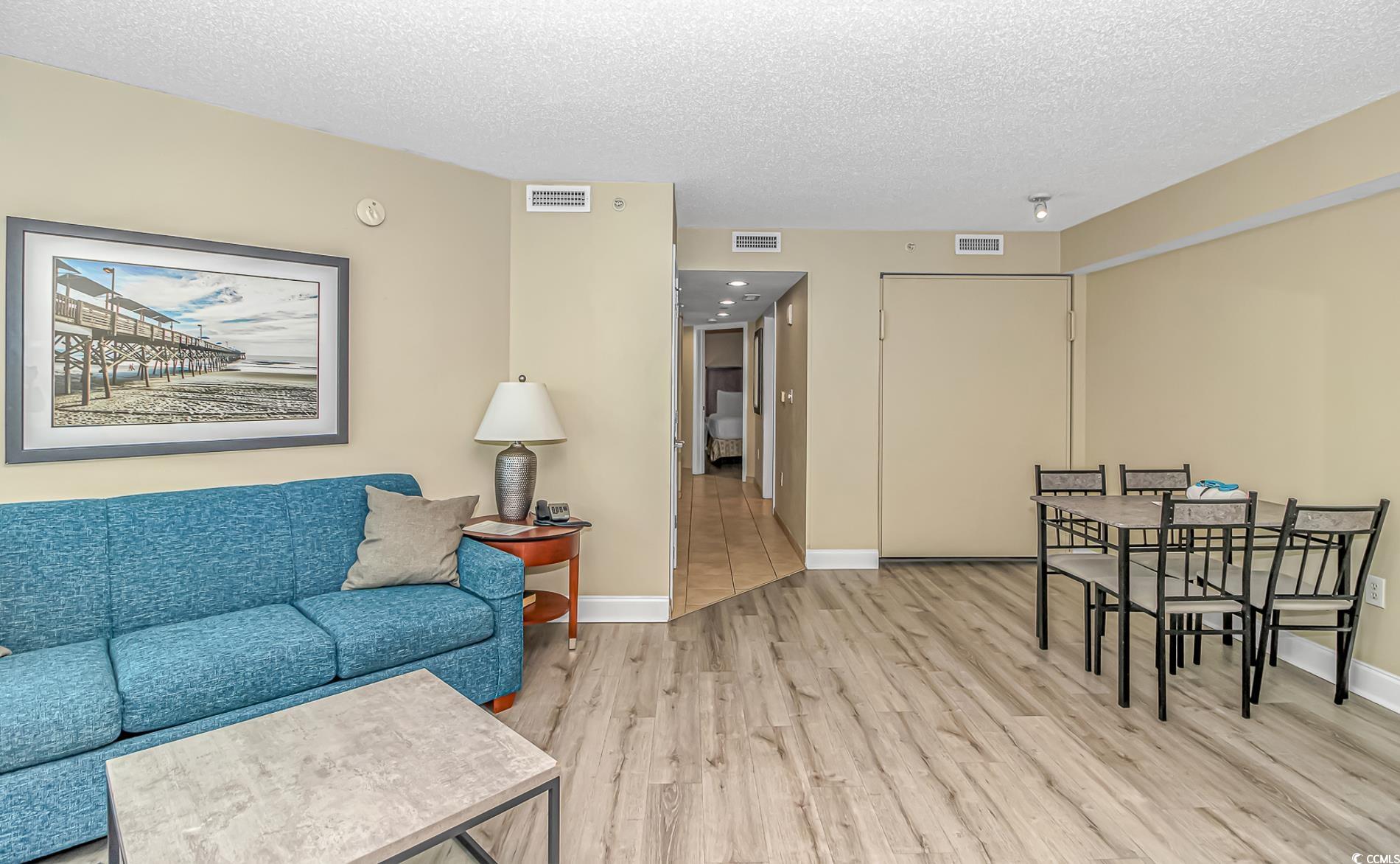 201 South Ocean Boulevard, Unit 1905 Myrtle Beach, SC 29577 - Photo 11 of 32 Living area with a textured ceiling and light wood-style floors