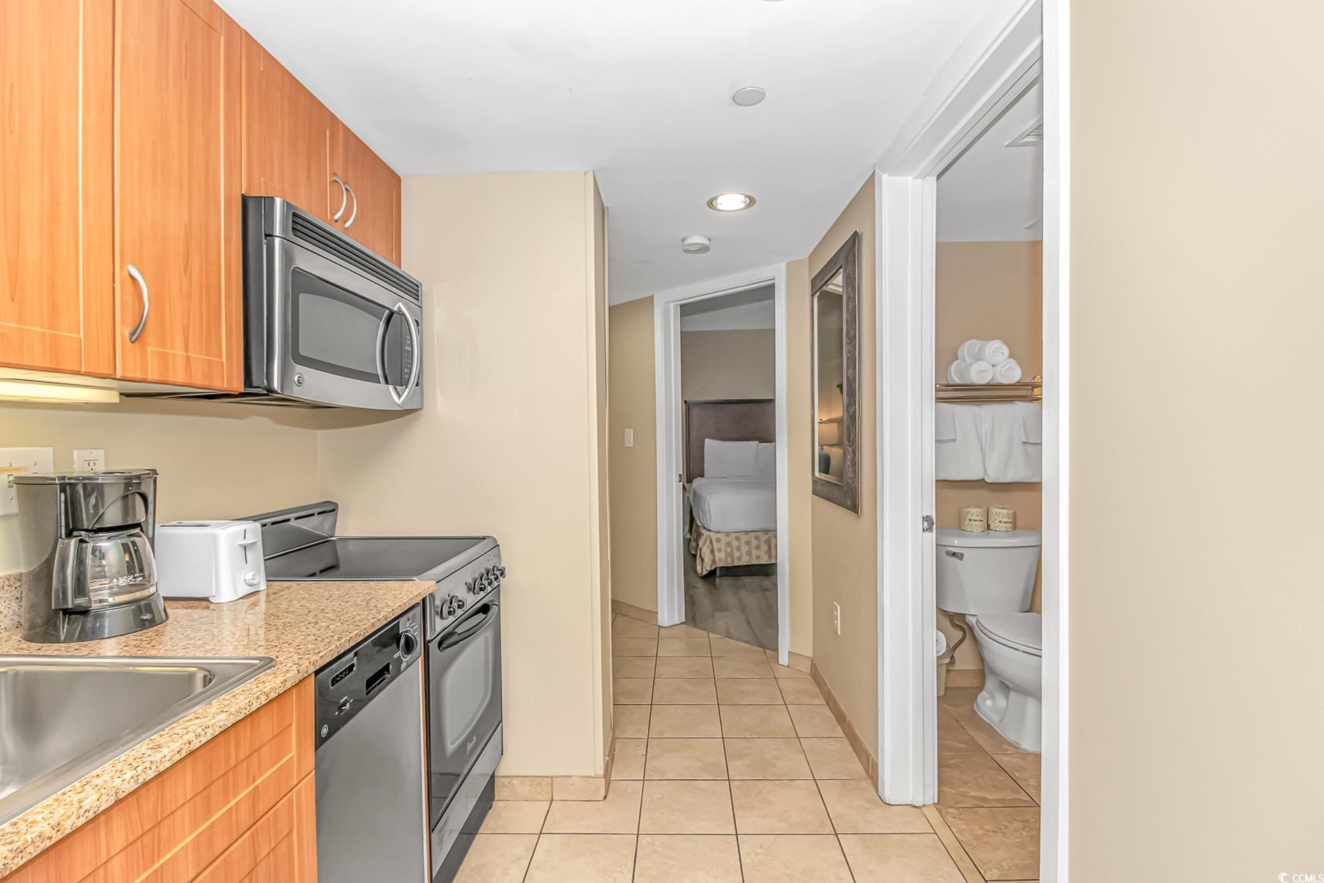 201 South Ocean Boulevard, Unit 1905 Myrtle Beach, SC 29577 - Photo 17 of 32 Kitchen with appliances with stainless steel finishes, light tile patterned flooring, recessed lighting, and brown cabinetry
