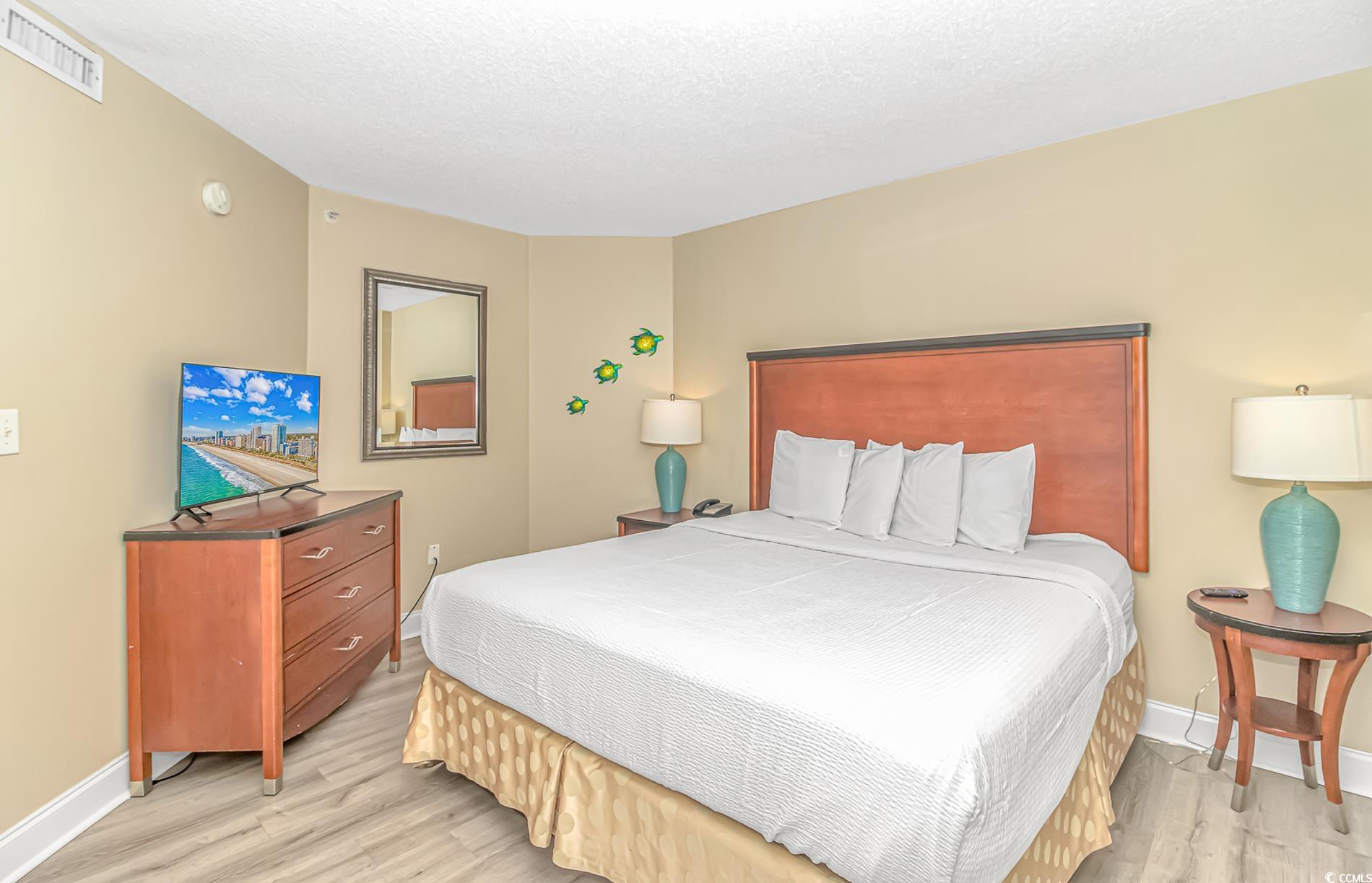 201 South Ocean Boulevard, Unit 1905 Myrtle Beach, SC 29577 - Photo 18 of 32 Bedroom featuring a textured ceiling and light wood-type flooring