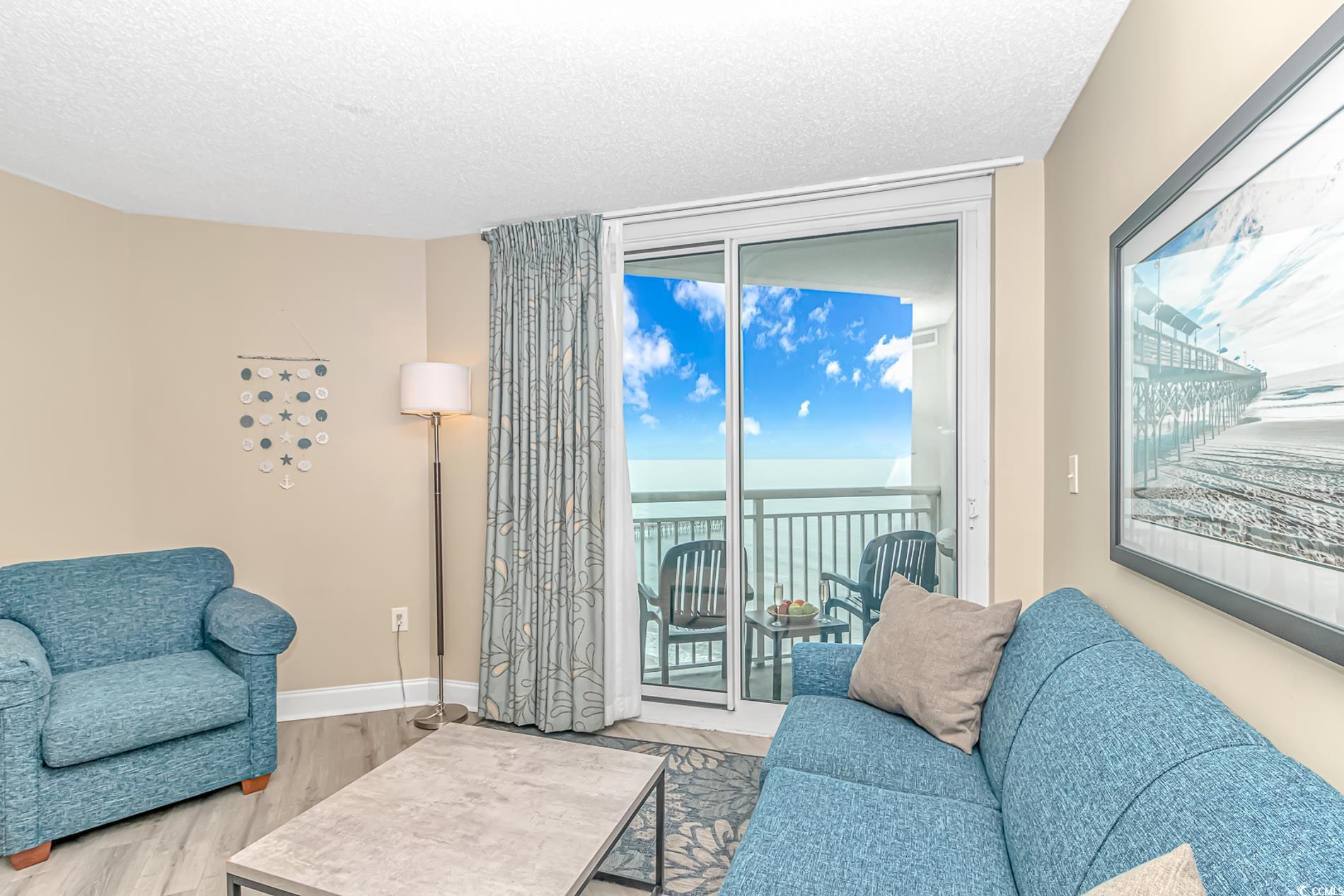201 South Ocean Boulevard, Unit 1905 Myrtle Beach, SC 29577 - Photo 4 of 32 Living room with a water view, wood finished floors, and a textured ceiling