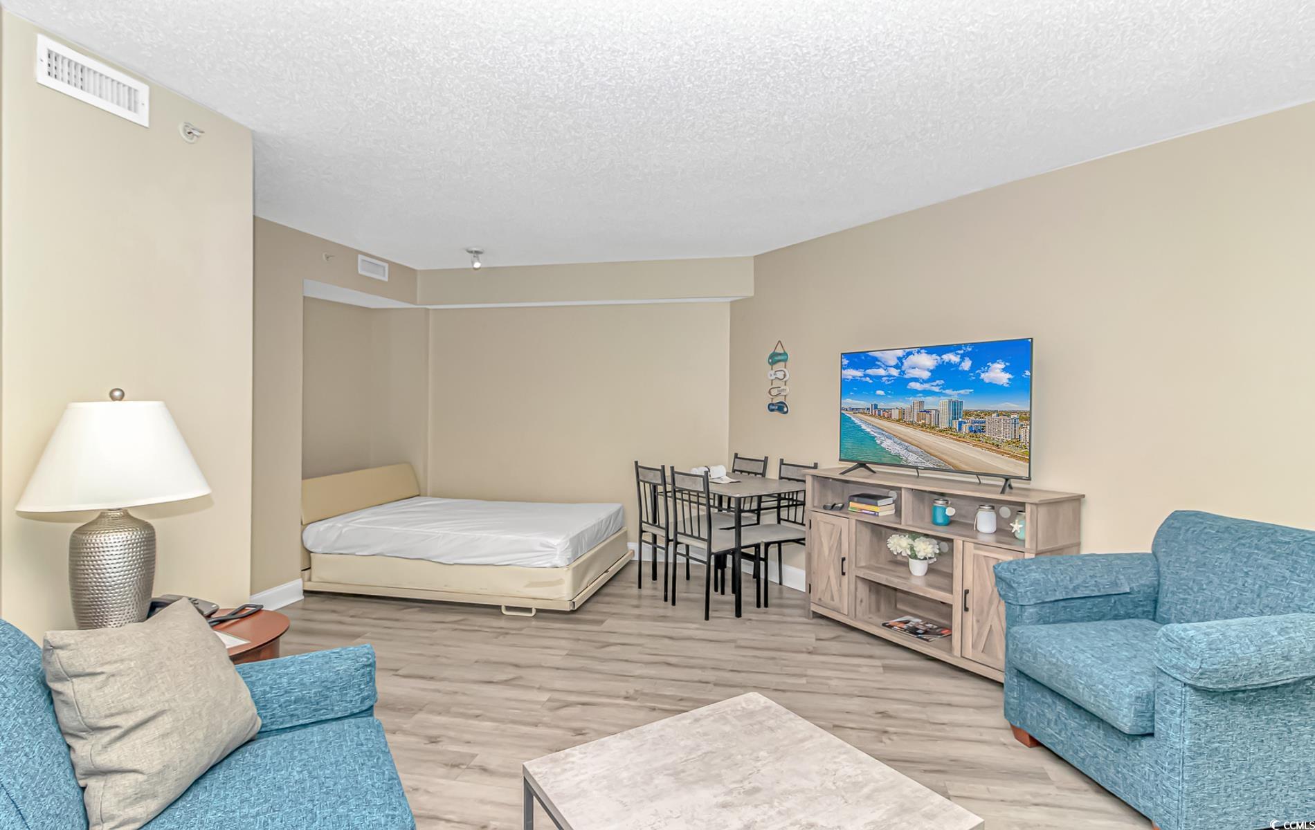 201 South Ocean Boulevard, Unit 1905 Myrtle Beach, SC 29577 - Photo 7 of 32 Bedroom with a textured ceiling and light wood-type flooring