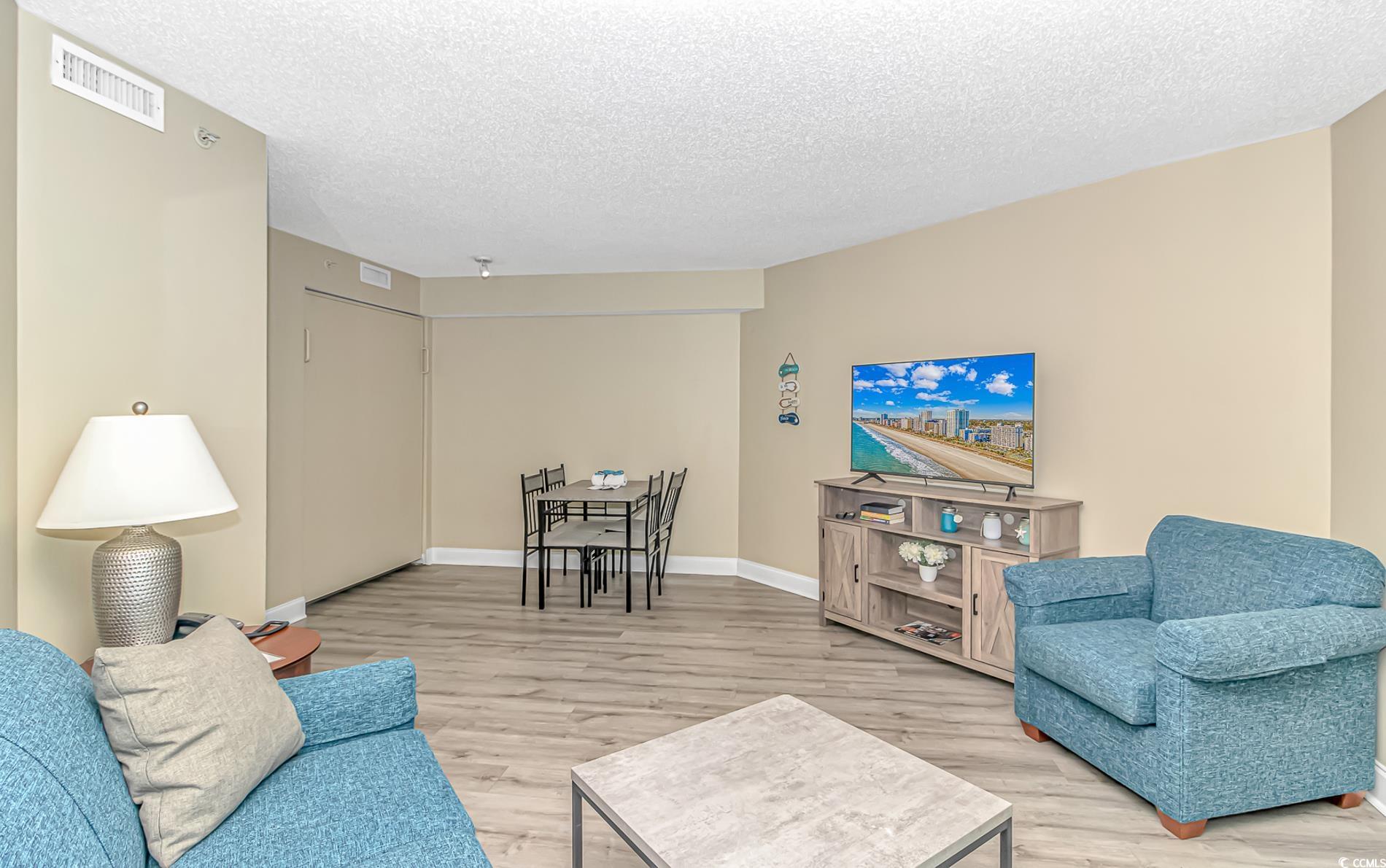 201 South Ocean Boulevard, Unit 1905 Myrtle Beach, SC 29577 - Photo 10 of 32 Living area featuring a textured ceiling and light wood-type flooring
