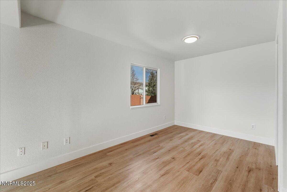 17598 Elk Court Reno, NV 89508 - Photo 18 of 43 an empty room with wooden floor and windows