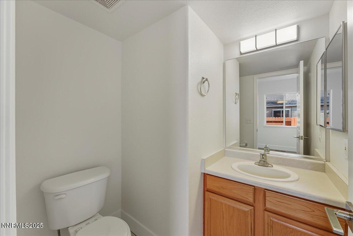 17598 Elk Court Reno, NV 89508 - Photo 20 of 43 a bathroom with a toilet sink a mirror and vanity