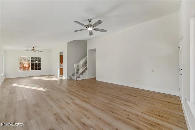 a view of a livingroom with wooden floor and a ceiling fan