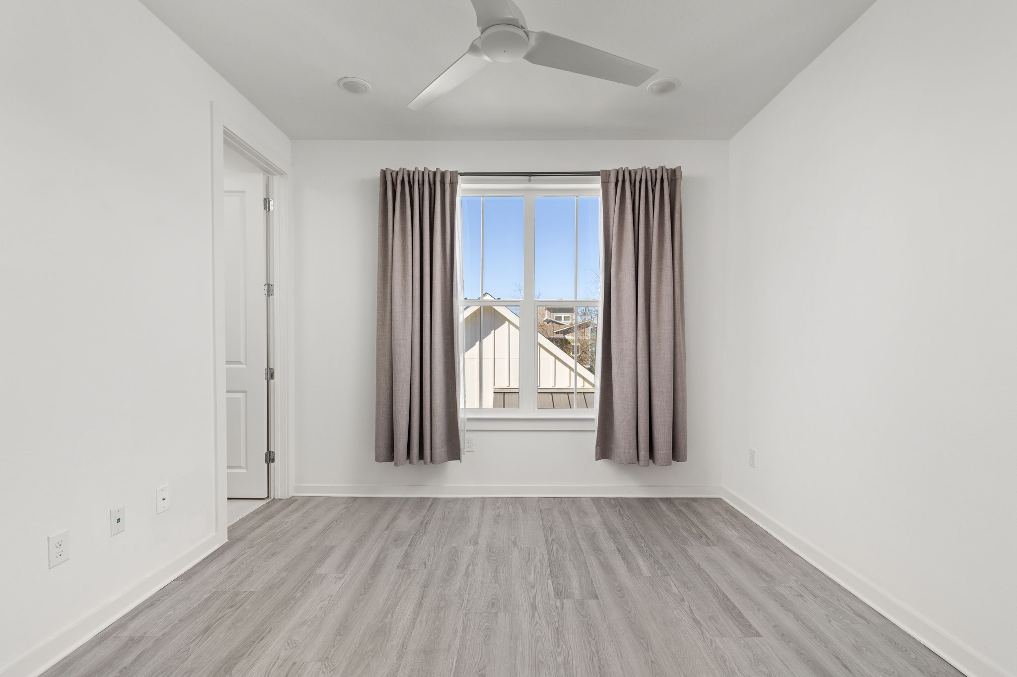 2624 Metcalfe Road, Unit 17 Austin, TX 78741 - Photo 17 of 35 an empty room with wooden floor and a window