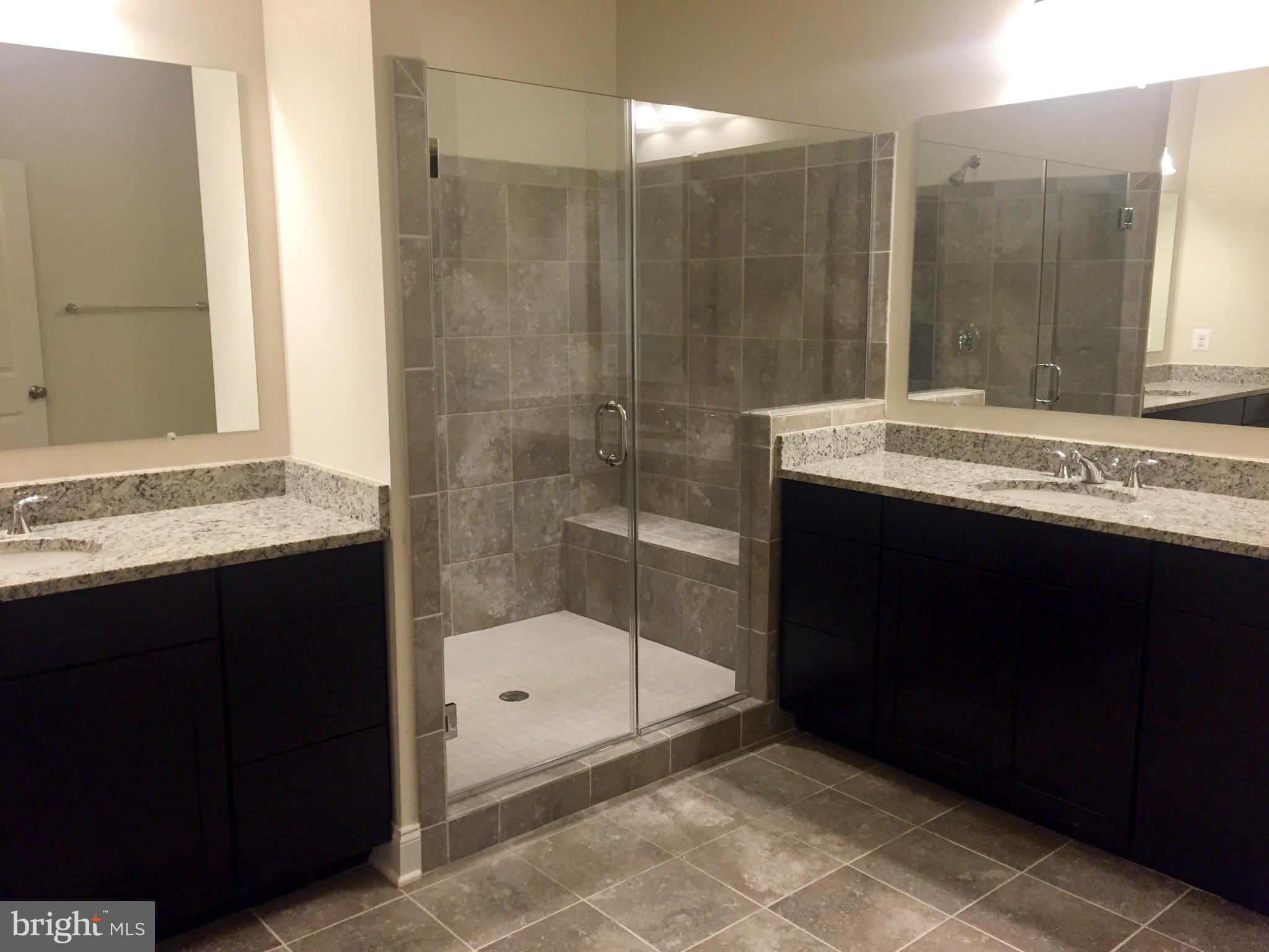 22595 Windsor Locks Square Ashburn, VA 20148 - Photo 5 of 13 a bathroom with a granite countertop sink a mirror and a bathtub