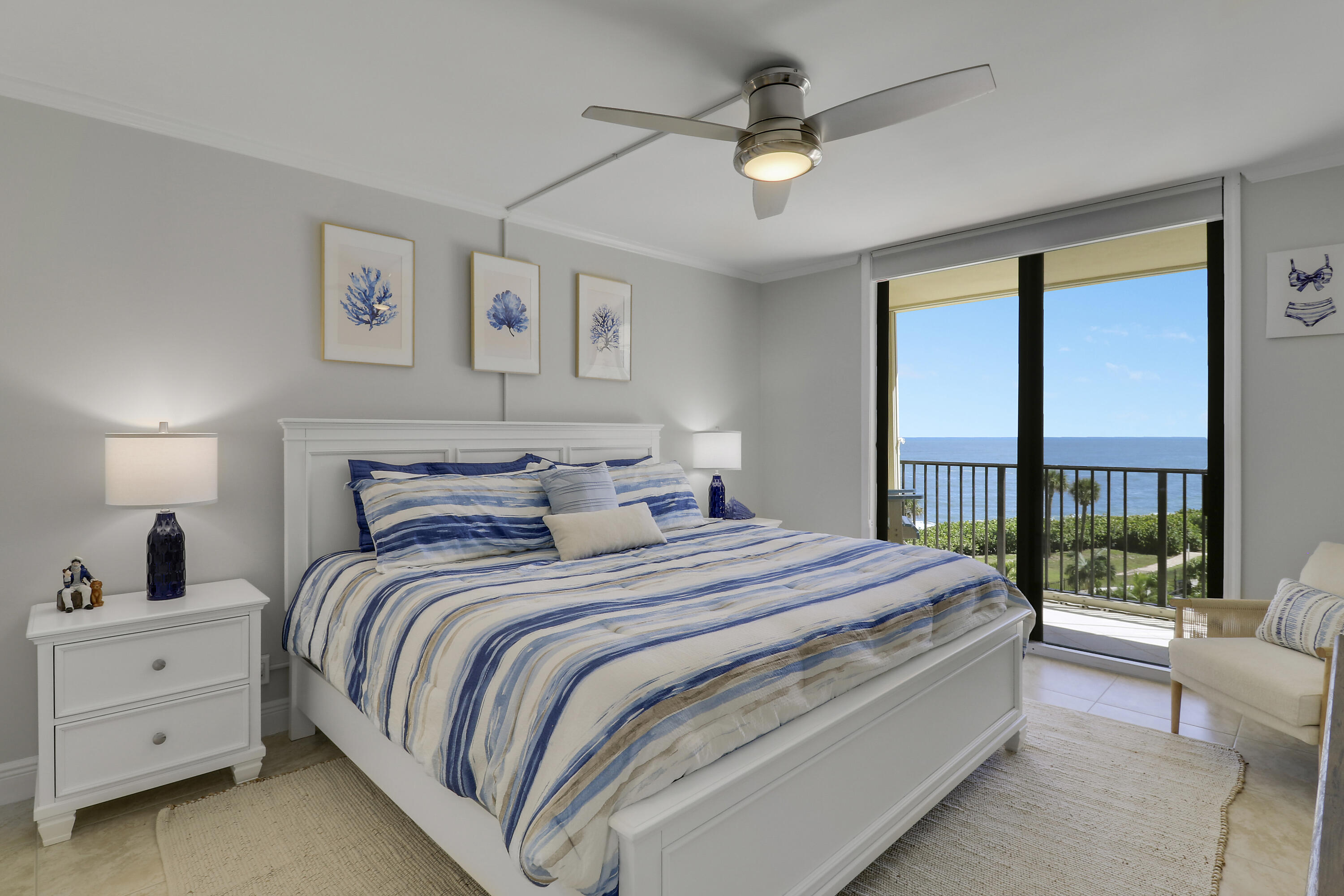 200 Ocean Trail Way, Unit 407 Jupiter, FL 33477 - Photo 11 of 22 a bedroom with a large bed and a chandelier fan