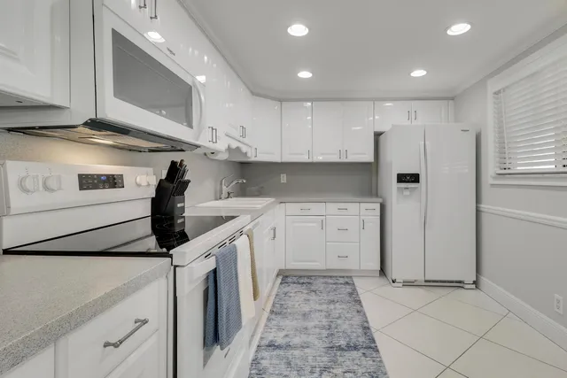 a kitchen with cabinets stainless steel appliances and sink