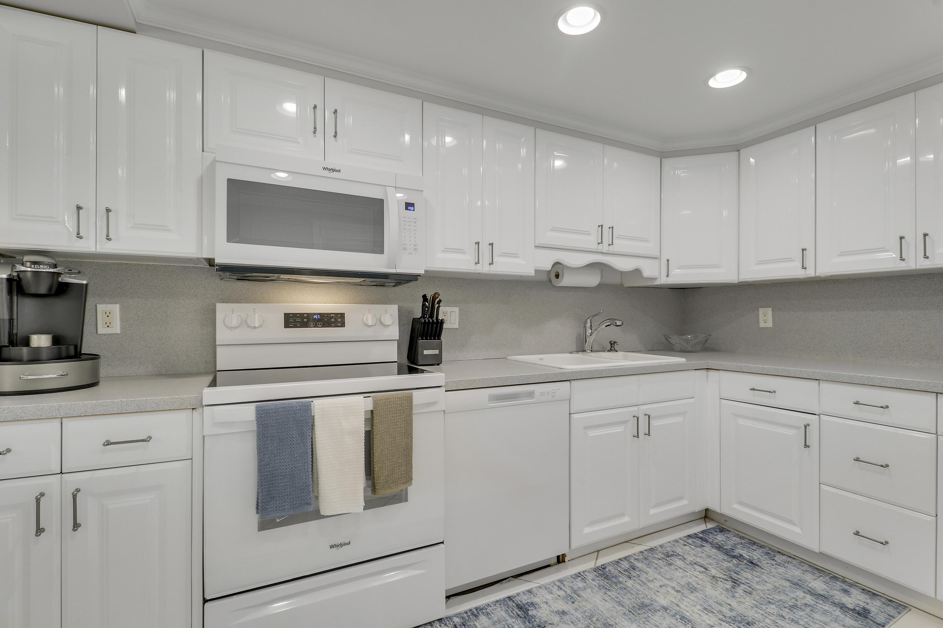 200 Ocean Trail Way, Unit 407 Jupiter, FL 33477 - Photo 18 of 22 a kitchen with cabinets appliances and a sink