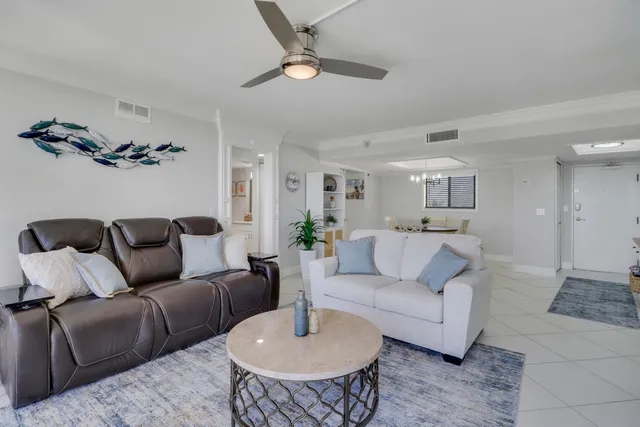 a living room with furniture a flat screen tv and a large window