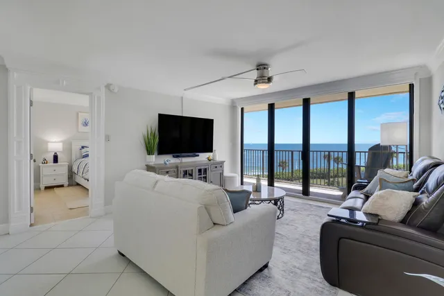 a dining room with furniture and a potted plant