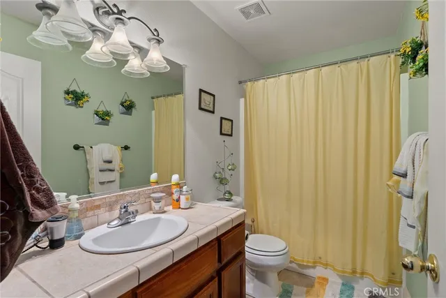 a bathroom with a sink a toilet and shower curtain
