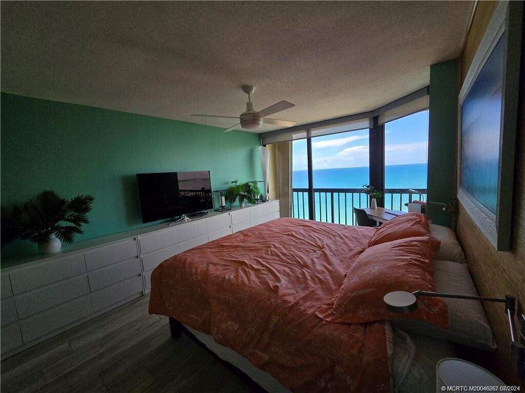 9500 South Ocean Drive, Unit 1908 Jensen Beach, FL 34957 - Photo 12 of 25 a bed sitting in a bedroom next to a window with a flat screen tv