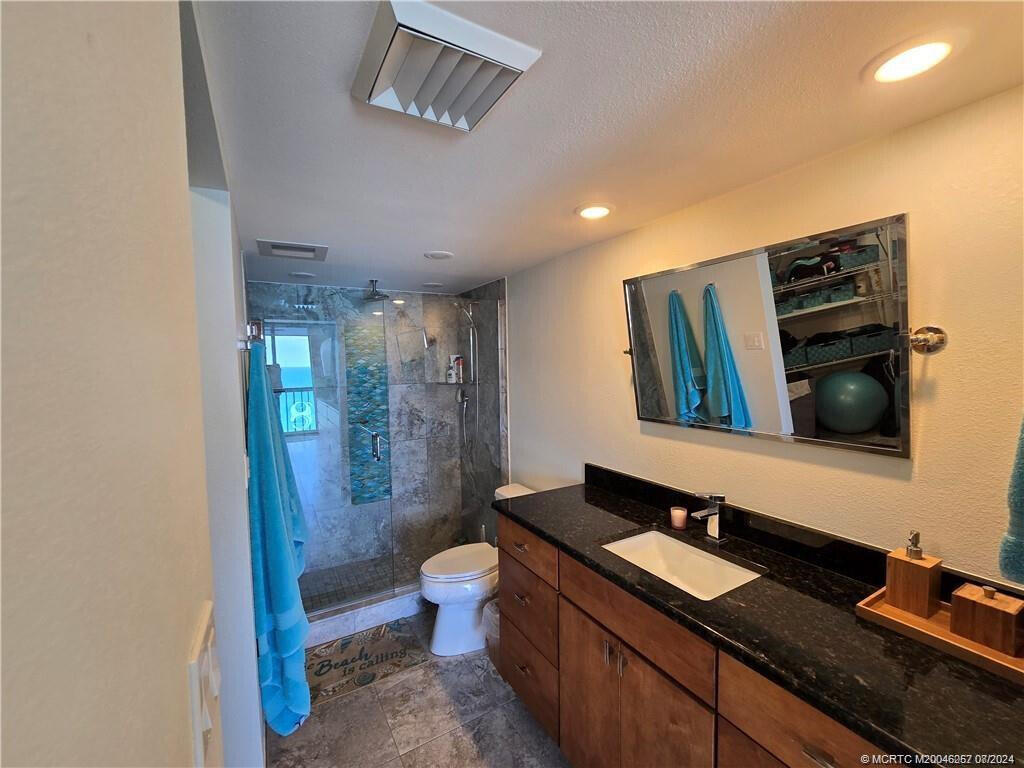 9500 South Ocean Drive, Unit 1908 Jensen Beach, FL 34957 - Photo 14 of 25 a spacious bathroom with a granite countertop sink a toilet a mirror and shower