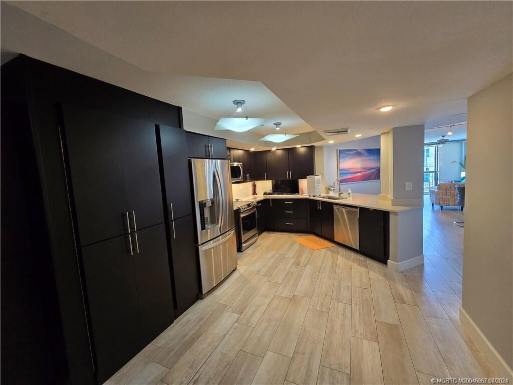 9500 South Ocean Drive, Unit 1908 Jensen Beach, FL 34957 - Photo 5 of 25 a large kitchen with stainless steel appliances a refrigerator and a sink
