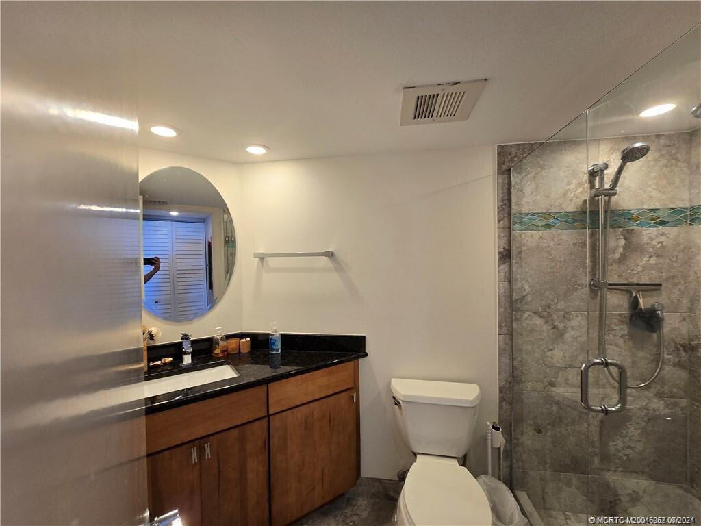 9500 South Ocean Drive, Unit 1908 Jensen Beach, FL 34957 - Photo 6 of 25 a bathroom with a toilet sink and mirror