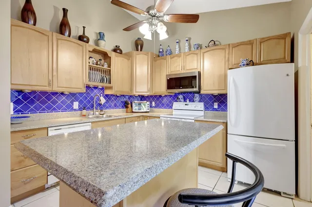 a kitchen with stainless steel appliances granite countertop a sink refrigerator and microwave