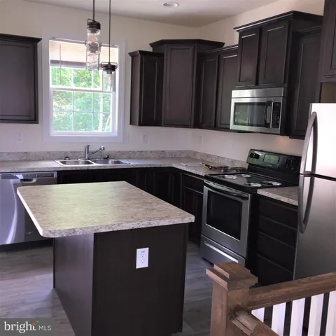 a kitchen with a sink stove and microwave