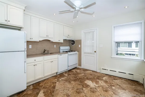a kitchen with granite countertop white cabinets and white appliances