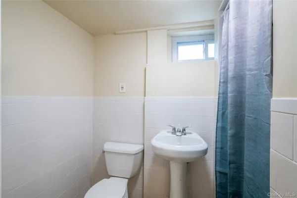 a bathroom with a sink a toilet and mirror