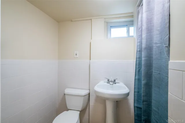a bathroom with a sink a toilet and mirror