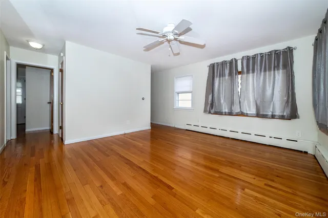 a view of a livingroom with wooden floor and a ceiling fan