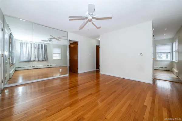a view of a room with wooden floor and ceiling fan