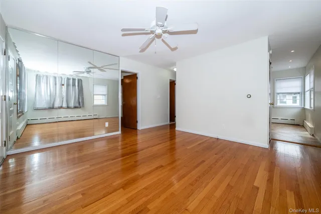 a view of a room with wooden floor and ceiling fan
