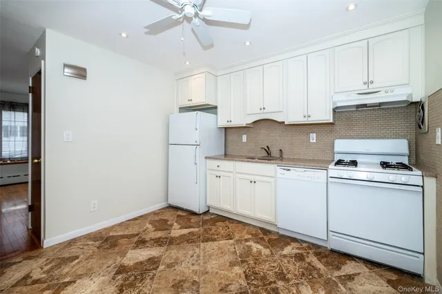 a kitchen with white cabinets and white appliances
