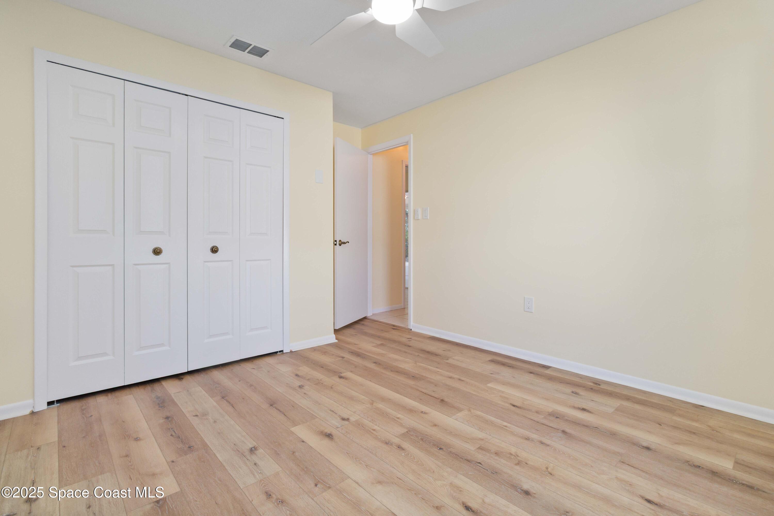 2355 Raintree Lake Circle Merritt Island, FL 32953 - Photo 28 of 47 a view of an empty room with wooden floor closet and chandelier fan