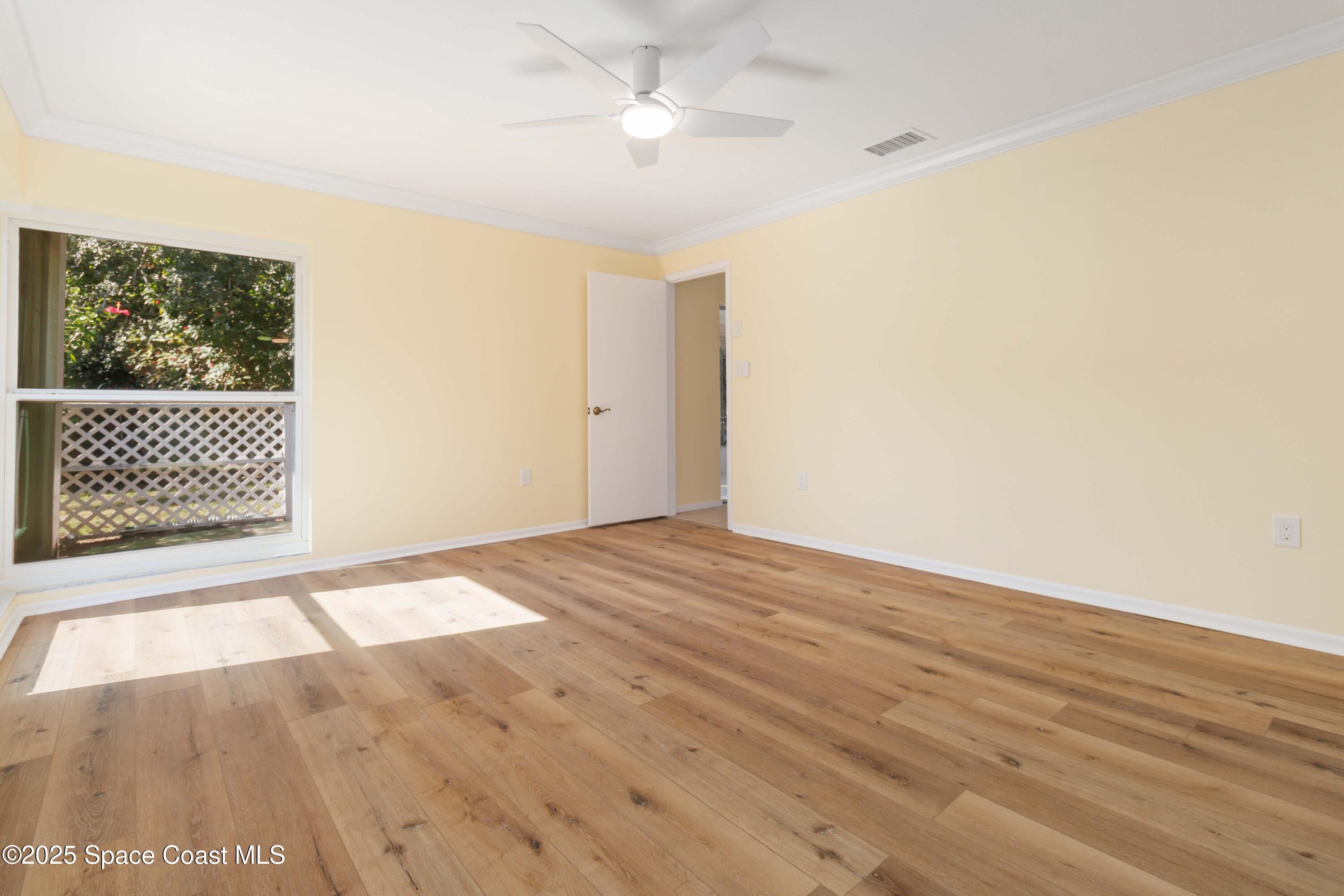 2355 Raintree Lake Circle Merritt Island, FL 32953 - Photo 32 of 47 an empty room with wooden floor fan and windows