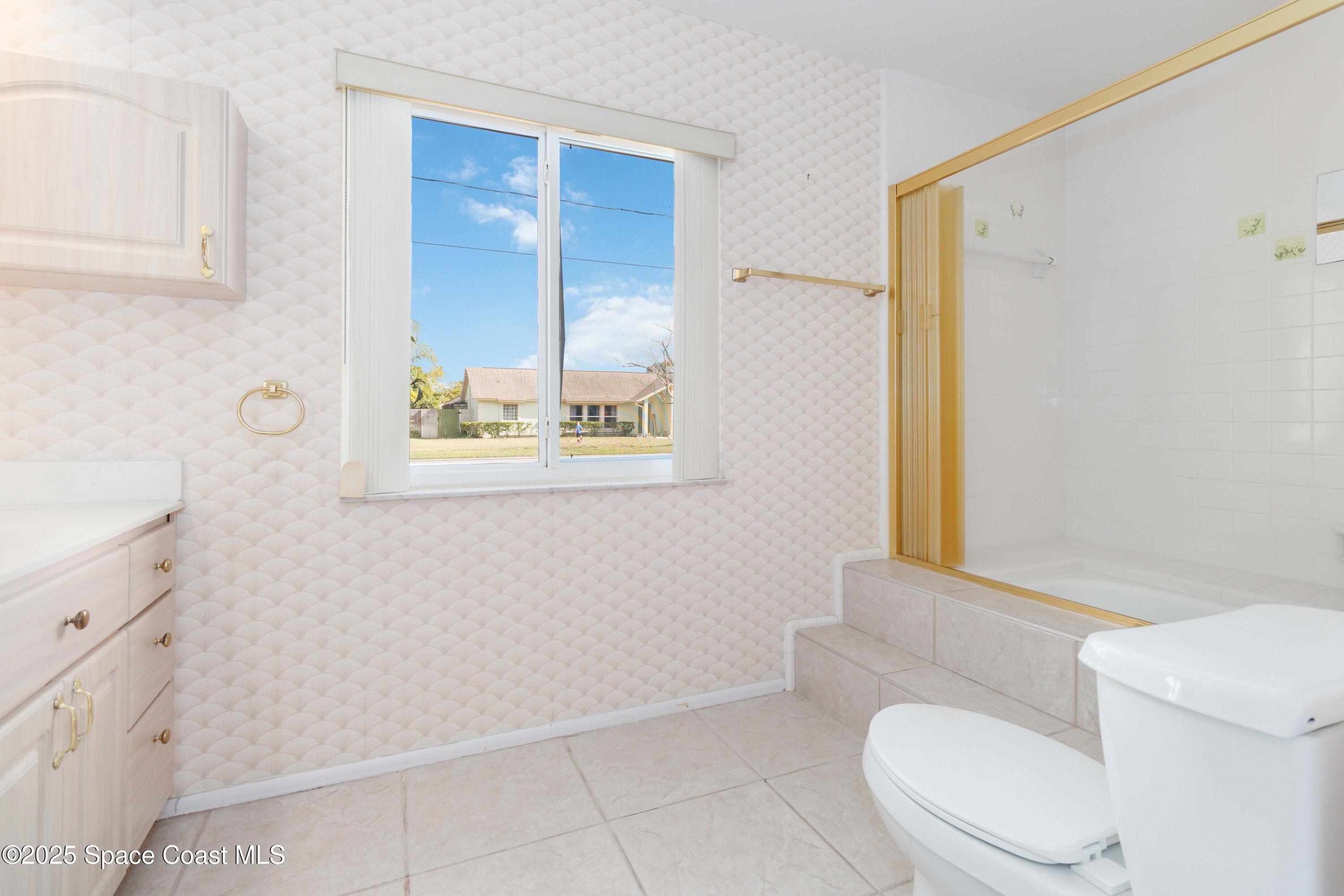 2355 Raintree Lake Circle Merritt Island, FL 32953 - Photo 33 of 47 a white toilet sitting next to a bathroom sink and a window