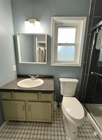 a bathroom with a toilet a sink and mirror