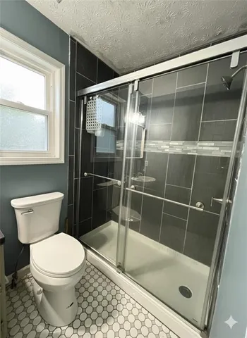a bathroom with a toilet and a shower