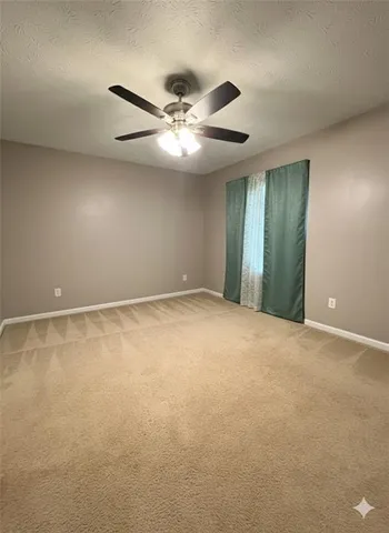 a view of an empty room with a ceiling fan