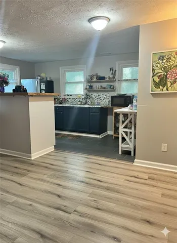 a view of a kitchen with cabinets and wooden floor
