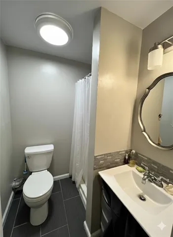 a bathroom with a toilet sink and mirror