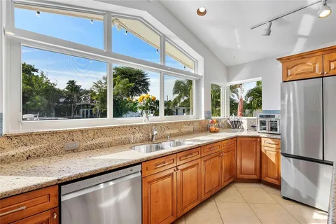 a kitchen with stainless steel appliances granite countertop a sink and a refrigerator