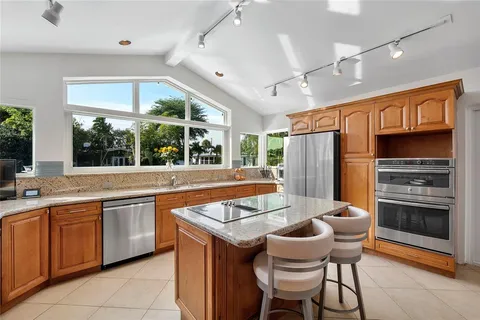a kitchen with stainless steel appliances granite countertop a sink and a refrigerator