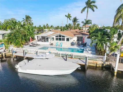 a roof deck with table and chairs couches with wooden floor and plants