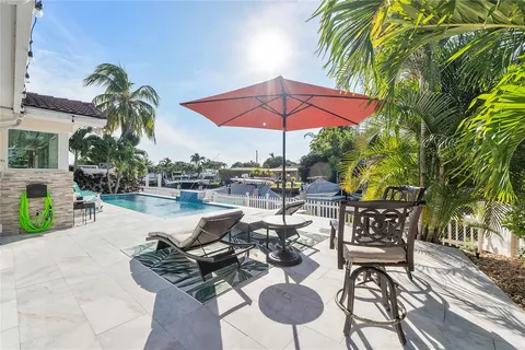 a living room with furniture a table and chairs under an umbrella
