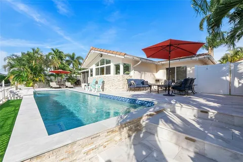 a view of a house with pool and sitting area