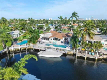 a front view of a house with a yard and potted plants