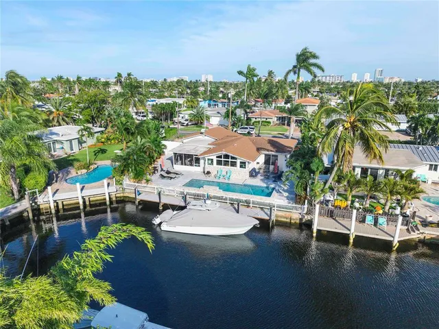 a front view of a house with a yard and potted plants