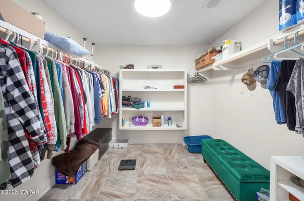 a view of walk in closet with clothes and shoes