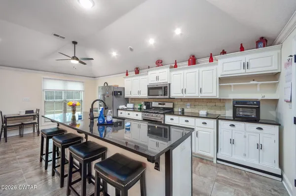 a kitchen with granite countertop cabinets a sink and appliances